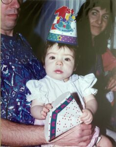 Eating disorder recover blog - Brown haired baby girl in white dress wearing a birthday hat